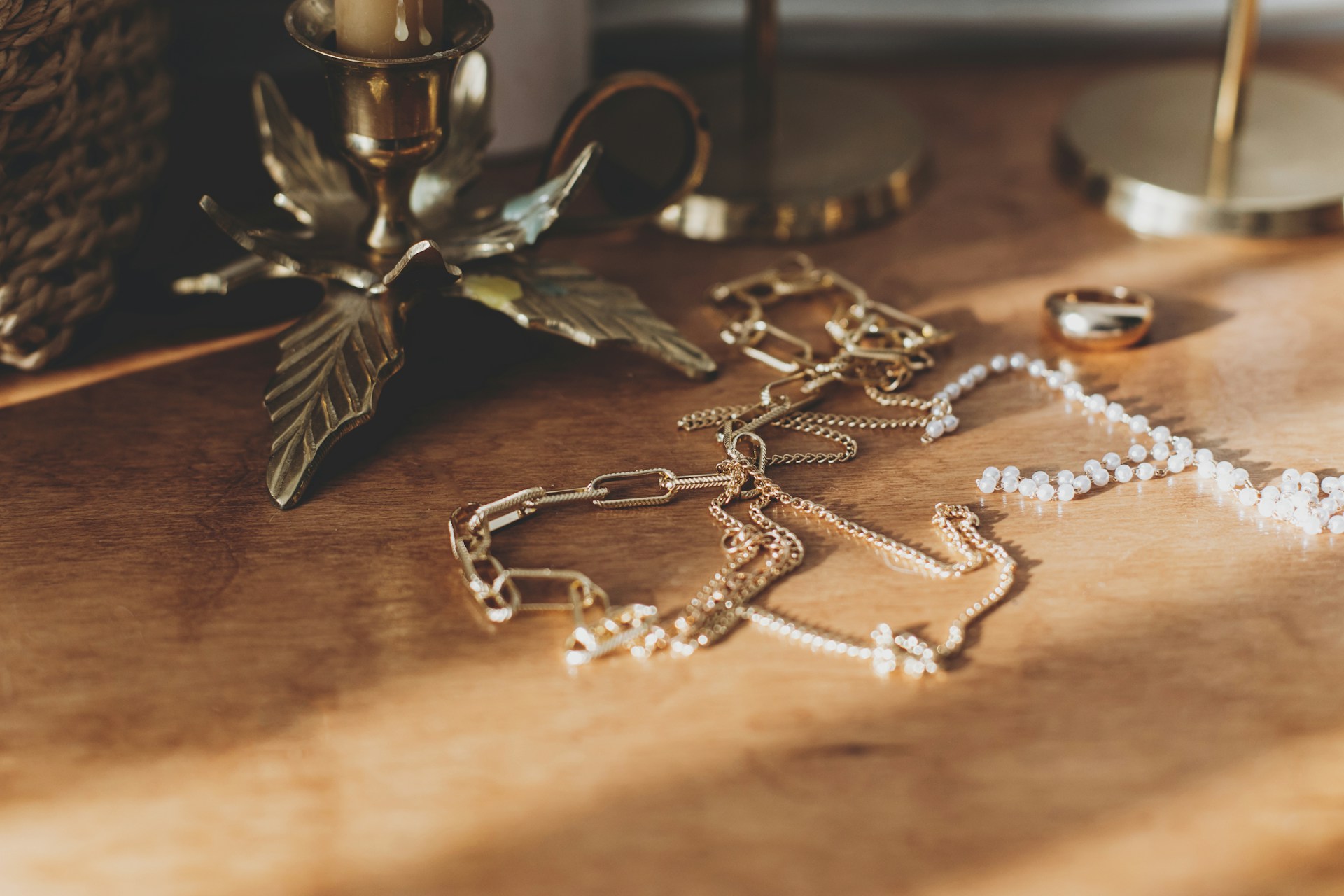 pieces of gold jewelry lying on a wooden surface next to vintage decor