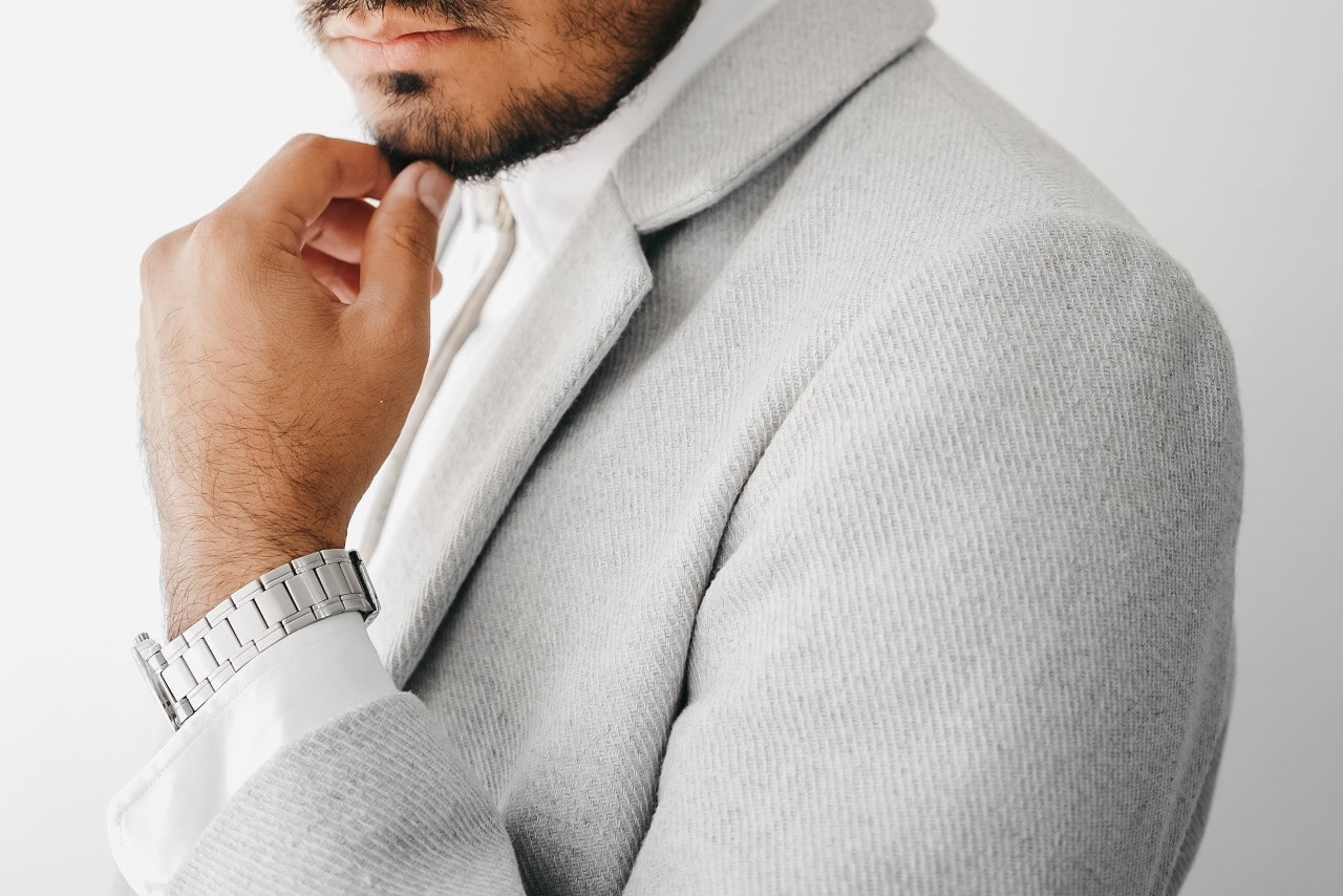 a man in a gray suit wearing a silver watch
