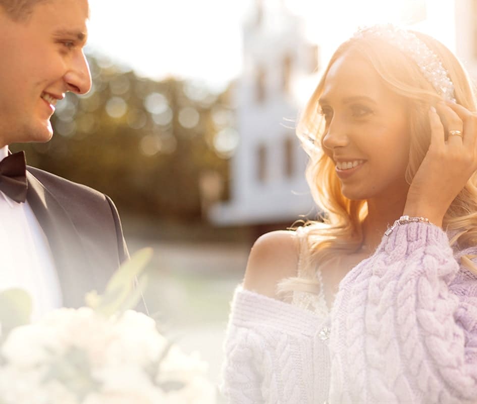 Man in suit holding flowers looking at her wife and she smiles