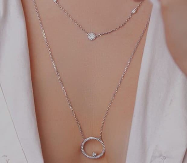 Two beautiful necklaces covering a woman's chest.