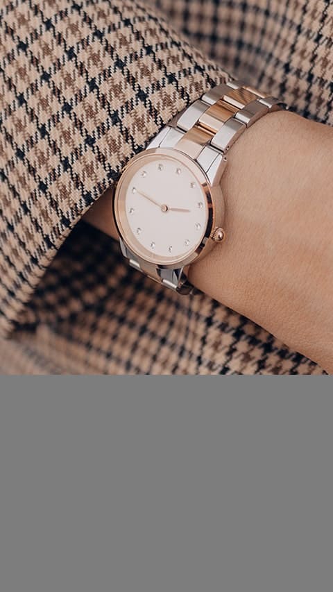 Man wearing a wrist watch on his right hand on a gray background