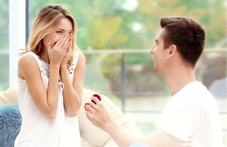 Man proposing to his girlfriend who is overjoyed at the gesture