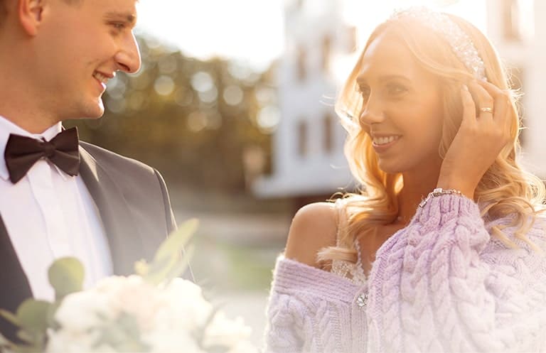 Man in suit holding flowers looking at her wife and she smiles