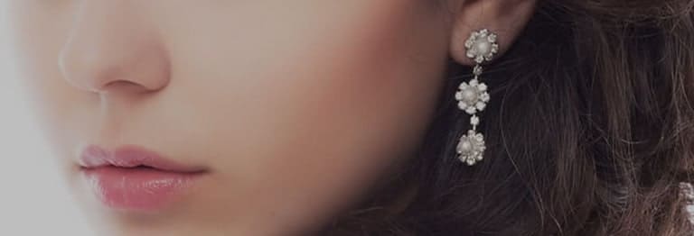 Woman wearing daisy earrings with pearls in the middle