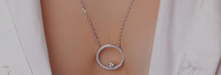 Two beautiful necklaces covering a woman's chest.