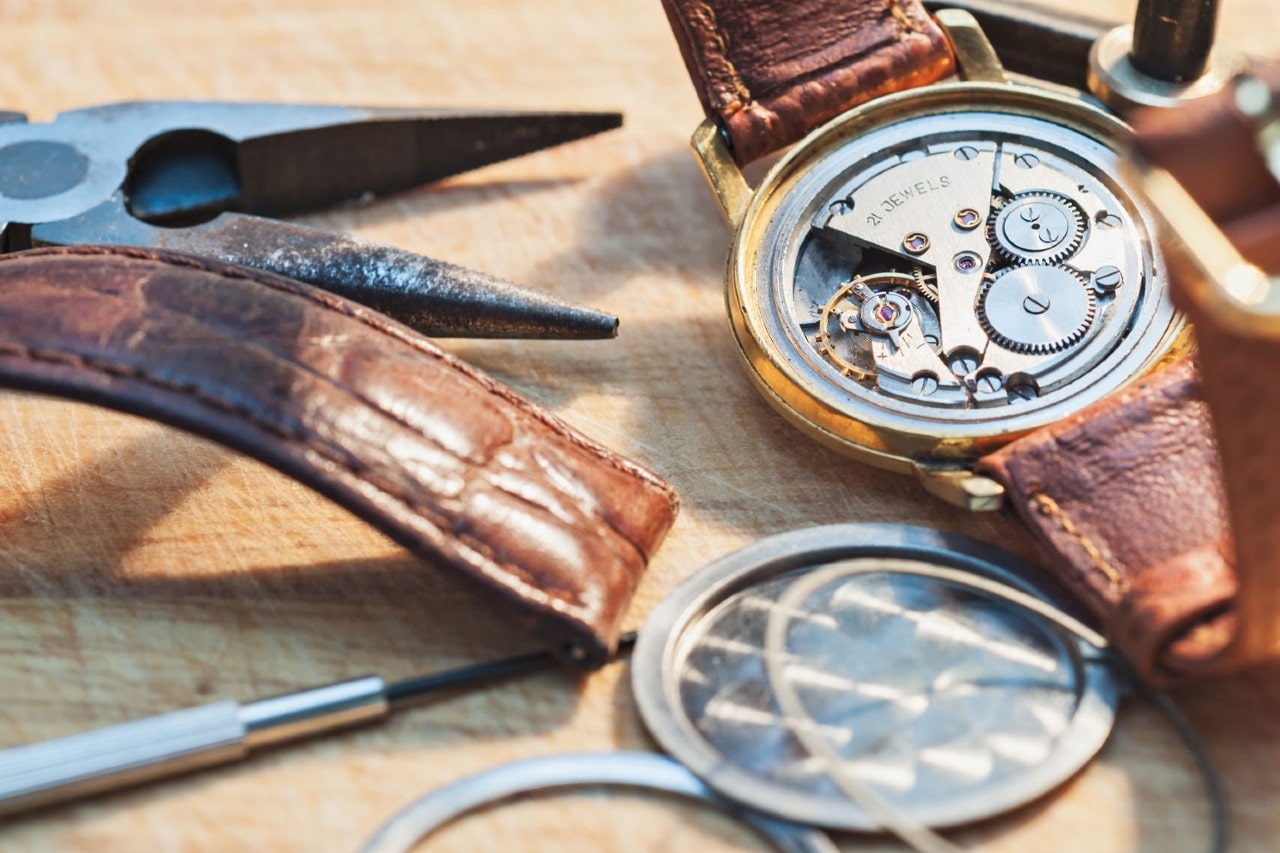 A pair of watches sitting on their face, their intricate machinery visible