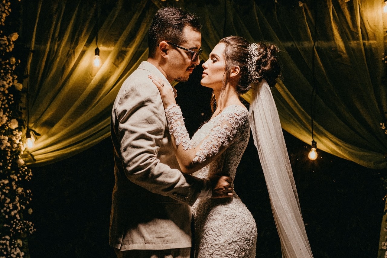 Bride and groom embracing in dim lighting