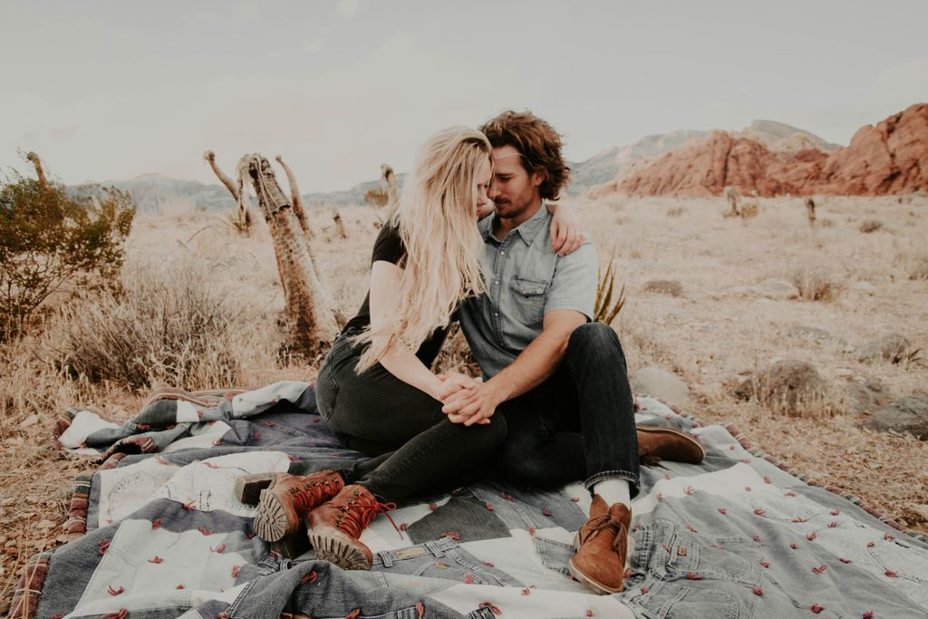 A woman wearing a round cut engagement ring embracing a man